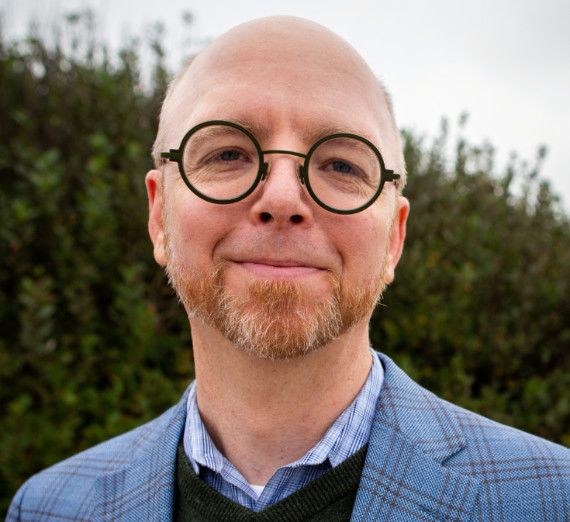 man with white hair at podium